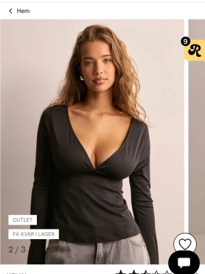 Svart långärmad topp med rosett - Trendig svart långärmad topp med djup v-ringning framtill. Aldrig använd och är i super fint skick. Stl S