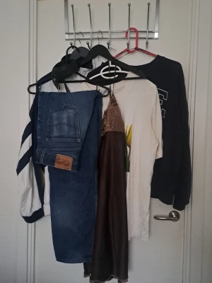 Klädpaket - Brun slipklänning i glansigt satinmaterial, tröja med tryck, collegetröja, jeans, vindjacka. Blandat skick. 