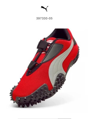 Puma röda sneakers storlek 44,5 - Snygga röda sneakers från Puma med svart och grå detalj, samt grov sula med gummipiggar för extra grepp. Ovandelen är i textil och syntet, med elastiska band istället för klassiska snören. Ikonisk Puma-logga på sidan och Ortholite-innersula för skön komfort.