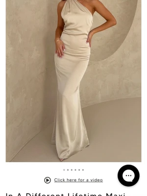 Oanvänd Champagnefärgad oneshoulder maxiklänning - Oanvänd maxiklänning med, prislapp sitter kvar! Elegant maxiklänning i champagnefärgat, glansigt tyg med figurnära passform och öppenrygg. Perfekt till bal, bröllop eller andra event! 