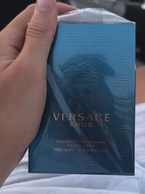 Versace Eros parfym 100 ml - Versace Eros parfym i en snygg blågrön förpackning med guldiga detaljer och Medusa-huvudet på framsidan. Flaskan rymmer 100 ml och är perfekt för dig som gillar exklusiva och fräscha dofter. En ikonisk doft från Versace som sticker ut.