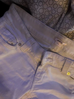 Vita ripped jeans från Gina Tricot - Snygga vita jeans från Gina Tricot med slitningar på benen och klassisk femficksmodell. Jeansen har normal midja och raka ben. Perfekta för dig som gillar en trendig och avslappnad stil.