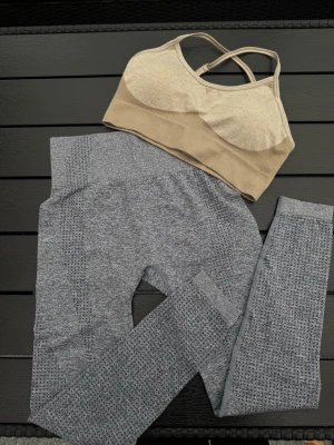 Grått seamless set med sport-bh - Säljer ett snyggt set med gråa sömlösa tights och en beige sport-bh med korsade axelband. Stretchigt material och de är helt oanvända.