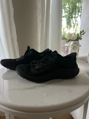 Svarta Nike skor - Säljer ett par helsvarta Nike skor. Använda väldigt få gånger då jag köpte ett par andra springskor samtidigt så dessa har tyvärr blivit stående. Inget fel på dem, kan användas som ”vanlig” sneakers samt löparsko. 