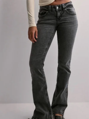 Svarta bootcut jeans från Gina Tricot - Bootcut jeans i svart tvätt från Gina Tricot med  klassiska fem fickor. Jeansen har en knappstängning fram och bakficka med lock och knappdetalj. Snygg passform och stretchigt material för extra komfort.