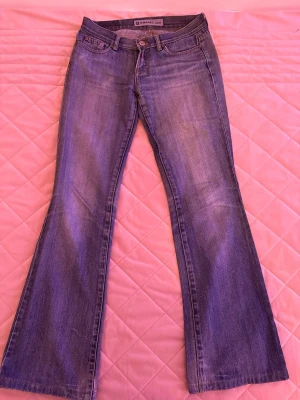 Blå bootcut jeans från Replay - Säljer dessa super fina blå bootcut jeans från Replay. Jeansen är låg midjade och är tillverkade i mjukt denimtyg. Bakfickan har Replay-logga och dekorativ söm. Passa till de som har storlek 34 eller 36