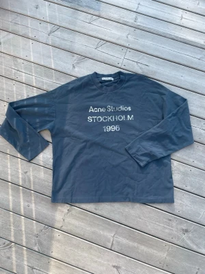Acne Studios Vintage Crewneck Longsleeve - Säljer den ikoniska longsleeve crewneck från Acne Studios. | Storlek S med den klassiska sköna passformen & den är i princip ny, endast testad. Färgen är mörkblå med vitt slitet tryck, riktigt fet och passar till det mesta med rätt stil 😉