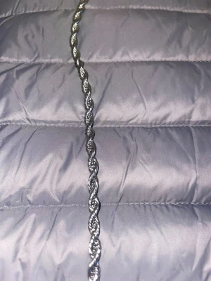 Cordell Halsband herr - Säljer ett stilrent halsband i silverfärg med tvinnad kedja. Halsbandet har en blank finish och ett klassiskt karbinlås. Perfekt för dig som gillar minimalistiska accessoarer med lite edge. Rostfri 
