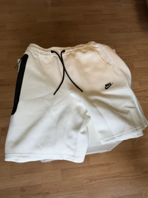 Vita Nike shorts med snörning - Säljer ett par vita shorts från Nike. Helt oanvända med prislapp. Fråga gärna om fler bilder!