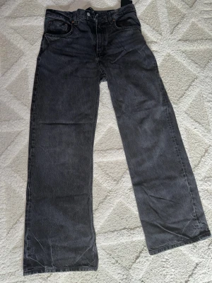 ZARA BOOTCUT JEANS - Snygga svarta jeans från ZARA med rak passform och klassisk femficksdesign. Jeansen har en tvättad look och är tillverkade i ett slitstarkt denimtyg. Perfekta för en avslappnad och trendig stil.