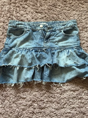 Volangkjol i denim från Gina Tricot - Jeanskjol från Gina Tricot med volanger. Säljer då den inte passar, strl 158 och fint skick!
