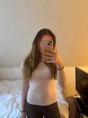 Ljusrosa tight t-shirt - Säljer en enkel och stilren ljusrosa t-shirt med rund halsringning. Modellen är tight och har korta ärmar, perfekt för att matcha med olika outfits. Materialet är mjukt och stretchigt. 