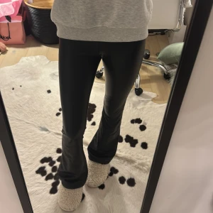 Svarta bootcut skinnbyxor - Svarta skinnbyxor från Zara, storlek 13-14 år hon i bilden är 163. Dom är lågmidjade. Inte mina bilder men samma byxor!