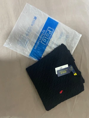 Stickad svart Polo Raplph - Lauren tröja - Helt ny svart stickad Ralph Lauren-tröja, mjuk och bekväm. Klassisk design med Ralph Laurens ikoniska logga. Skick [10/10]. Storlek [M]. Säljes för [599]. Hör av dig om du vill ha fler bilder eller mer info!🥂