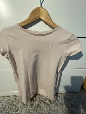 Ljusrosa tröja från H&M  - Super söt babyrosa T-shirt från hm med ett litet hjärta vid bröstet. Passar med det flesta. 