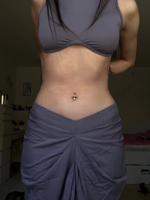 Grey/purple matching low waisted maxiskirt & top set (XS/S) - Mycket bra skick, använd en gång – behöver bara strykas. Matchande tvådelat set med en lågmidjad “v-formad” figurnära kjol och topp. Väldigt smickrande passform och lätt att styla tillsammans eller var för sig. Grå med lila undertoner. Perfekt för en utekväll eller middag. Väldigt stretchigt material. Storlek XS/S.  Great condition, used once it just needs to be ironed. Matching two-piece set with a low waisted ”v-line” fitted maxi skirt and top. 