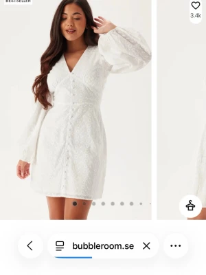 Vit kort klänning med ballongärmar - Superfin vit kort klänning med broderade detaljer och ballongärmar. Klänningen har v-ringning, markerad midja och knappar framtill. Perfekt för studenten eller sommarens alla tillfällen. Enbart provad, säljes då den tyvärr inte passar mig. Kan skickas men köparen står för frakten💕