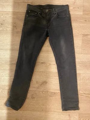 Svarta slim fit jeans - Snygga svarta slim fit jeans med klassisk femficksdesign och dragkedjegylf. Jeansen har en lätt tvättad look och smal passform som sitter tajt längs benen. Perfekta för en stilren och modern outfit.
