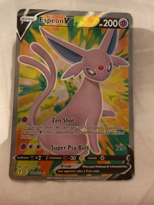 Pokémonkort Espeon V - Säljer ett färgglatt Pokémonkort med Espeon V, en lila psykisk Pokémon med 200 HP. Kortet har holografisk yta och coola attacker som Zen Shot och Super Psy Bolt. Perfekt för samlare eller dig som vill boosta din lek!