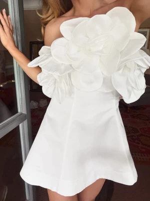 Vit axelbandslös klänning  - Superfin vit axelbandslös kortklänning med stor 3D-blomma framtill. Från Lovisa Wallins kollektion med nakd. Passade tyvärr inte mig.
