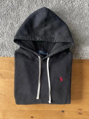 Svart hoodie från Polo Ralph Lauren - Svart Ralph Lauren hoodie i storlek M säljes. I mycket bra skick och utan defekter. Stilren och bekväm hoodie som passar till allt.  ✅ Storlek M ✅ Mycket bra skick ✅ Inga defekter ✅ Snabb frakt  Hör gärna av er vid frågor eller om ni vill ha fler bilder!