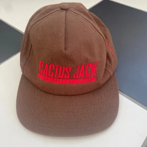 Travis Scott-Cactus Jack keps brun  - Säljer min Travis Scott-Cactus Jack keps med broderade detaljer! Väldigt sparsamt använd och bra passform! Toppen nu inför vår och sommaren! Priset går att ändra!! 