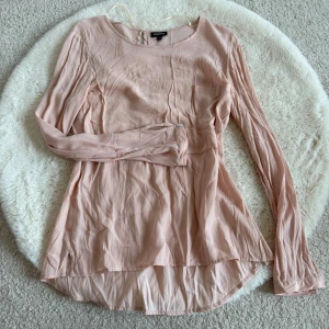 Ljusrosa blus från KappAhl (S) - Säljer en ljusrosa blus från KappAhl i storlek 36. Blusen har långärmad design, rund halsringning och är tillverkad i ett tunt, lätt material som ger ett flowigt och avslappnat intryck. Perfekt för att skapa en snygg och enkel look.