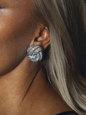 Glittriga örhängen från Mockberg - Säljer ett par snygga örhängen från Mockberg i silverfärg med glittriga stenar. De har en unik, knutliknande form och är perfekta för att ge din look extra bling. Kommer i originalask.