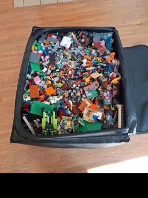 Stor låda med 15,7 kg blandat lego - Säljer en stor låda fylld med massor av blandade LEGO-bitar i olika färger och former som väger 15,7 kg. Perfekt för dig som vill bygga fritt och skapa egna projekt. Innehåller både plattor, hjul, figurer och specialdelar. Allt ligger samlat i en svart förvaringslåda.