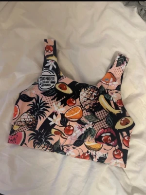  träningsset från Stronger - snyggt träningsset från Stronger med sport-bh och tights. Setet har ett fruktmönster med ljusrosa botten. Storlek S 