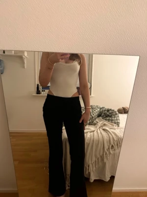 Svarta kostymbyxor  - Snygga svarta kostymbyxor med utsvängda ben och låg midja. Stretchigt material som sitter bekvämt och formar sig efter kroppen. Perfekta för en trendig och avslappnad stil.