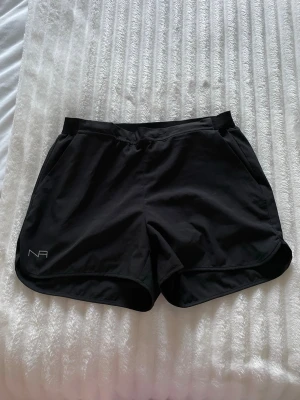 Svarta träningsshorts - Svarta träningsshorts med innerbyxa i grått. Shortsen har en elastisk midja och praktiska fickor. Perfekta för dig som gillar att röra på dig och vill ha bekväma shorts💪🏃‍♀️‍➡️