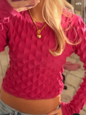 Mönstrad rosa långärmad topp - Trendig rosa topp med 3D-struktur och lång ärm. Materialet är stretchigt och ger en cool effekt. Perfekt att styla med jeans eller kjol för en snygg look. Passar super till en fest eller nu i somma me en kjol 