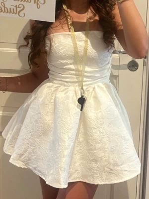 Vit studentklänning - Säljer nu min underbara studentklänning som endast är använd en gång. Den har en avtagbar rosett om man skulle vela sätta på den där bak. Själv tog jag av den men den medföljer såklart. Köpt på babyboo för 1500 kr. Storlek S. Mått på sista bilden.