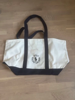 Ralph Lauren väska  - Säljer denna axelväska från Ralph Lauren - gjort i tyg - perfekt för dagsresor - mycket fin och helt ny!
