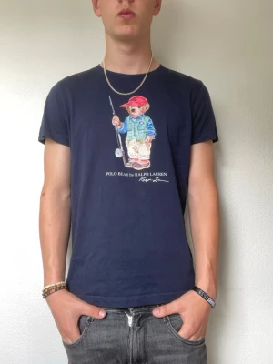 Mörkblå Polo Bear t-shirt Ralph Lauren - Modellen är 178cm och väger cirka 70kg. Storlek medium men passar mer som en small. Nypriset är cirka 1600kr medans jag säljer denna för endast 499kr. Hör gärna av er vid intresse!