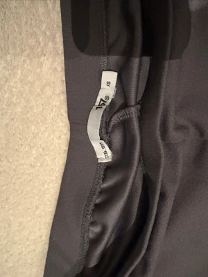Mörkgrå leggings från 157 - Säljer ett par mörkgrå leggings från 157 (säljs inte i butiken längre) i storlek XS. De har en tight passform och är tillverkade i ett stretchigt material som sitter skönt mot kroppen. Perfekta att matcha med oversized tröjor, hoodies eller till gymmet. 