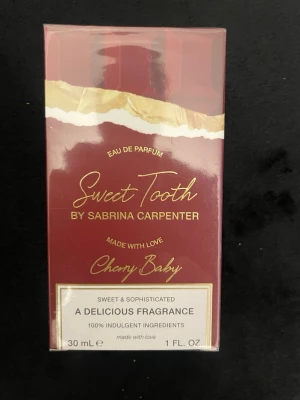 Sweet Tooth Cherry Baby parfym 30 ml - Ny och oöppnad förpackning, den är fortfarande inplastad. Sweet Tooth Cherry Baby Eau de Parfum från Sabrina Carpenter. Parfymen kommer i en elegant vinröd och guld kartong med lyxig känsla. Doften beskrivs som söt och sofistikerad med inslag av körsbär. Flaskan rymmer 30 ml.