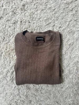 Brun ribbstickad tröja Even&Odd - Säljer en brun ribbstickad tröja från Even&Odd. Tröjan har rund halsringning, långa ärmar och är figurnära i modellen. Perfekt basplagg i garderoben och enkel att styla till olika outfits.