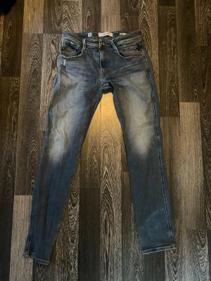 Replay jeans slim fit 32x34 - Snygga blå slim fit jeans från Levi's med slitningar och ljusa partier på benen. Klassisk femficksmodell med läderpatch bak i midjan och en liten reva på ena bakfickan. Perfekta för en avslappnad och trendig look. Finns ett hål i bakreficka men det passar in snyggt som slitning ny pris runt 1200