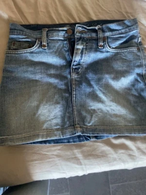 Lågmidjad Blå jeanskjol  - Snygg blå lågmidjad jeanskjol❣️den har två små fläckar där bak som knappt syns och förmodligen går bort i tvätten, köpte den här från Plick men den passade inte därför säljer jag den🫰🏼