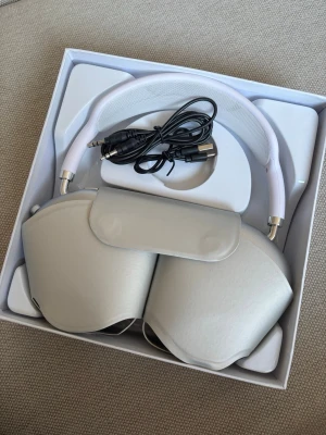AirPods Max silver hörlurar - Snygga liknelser av AirPods Max i silver med mjuka öronkuddar och vit huvudbygel. Levereras med smart case och laddningskabel. Perfekta för musik, gaming eller film! Dock ingen brusreducering