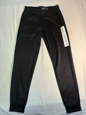 Svarta EA7 Emporio Armani mjukisbyxor - HELT NYA EA7 emporio armani mjukisbyxor med LAPPEN KVAR och ett par välanvända HUGO BOSS PÅ KÖPET. Båda byxorna är i storlek S men passar M skulle jag säga. Var tyvärr för sen med att lämna tillbaka dom så får sälja dom till någon annan lyckligt lottad. EA7 betalade jag 1000kr för och Hugo bossen 1300 men den som slår till får båda för 800+frakt alt 600 för EA7 och 200 för boss
