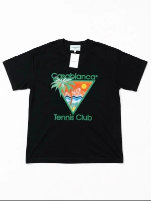 Svart Casablanca Tennis Club t-shirt - Snygg svart t-shirt från Casablanca med färgglatt tryck framtill som visar palmer, berg och sol. Texten 'Casablanca Tennis Club' i grönt ger en sportig vibe. Klassisk passform och rund halsringning. Perfekt för dig som gillar streetwear och grafiska prints.