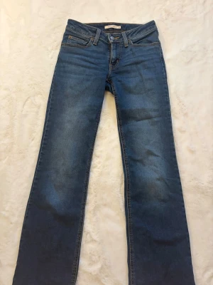 Blå bootcut jeans  - Säljer ett par low waist Levis jeans. I storlek 24 i midjan och i längden passar mig perfekt som är 167