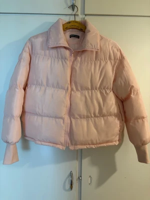 Ljusrosa pufferjacka SHEIN  - Säljer en ljusrosa pufferjacka med hög krage och dragkedja framtill. Jackan har en boxig passform och breda kanaler som ger en riktigt fluffig look. Perfekt för kalla vinterdagar och riktigt snygg till streetwear-stilen. Lite nopprig vid händerna som man ser på sista bilden men annars helt ny.