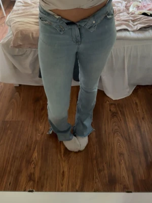 Ljusblå bootcut jeans med låg midja - Säljer att par ljusblåa bootcyt jeans. Använt fåtal gånger. Har en vit fläck på sidan som ni ner på bilden. 