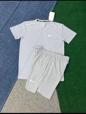 Ljusgrått träningsset från Nike - Säljer ett ljusgrått träningsset från Nike med t-shirt och shorts. Setet har en sportig design med vita Nike-loggor på både tröjan och shortsen. Tillverkat i ett lätt och snabbtorkande material som passar perfekt för träning eller gym.