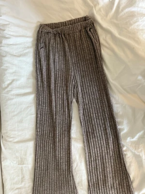 Ribbat loungewear-set i gråbrunt - Mysigt loungewear-set med ribbade byxor och matchande tröja i gråbrun nyans. Vet tyvärr inte storlek men skulle gissa på M-L.