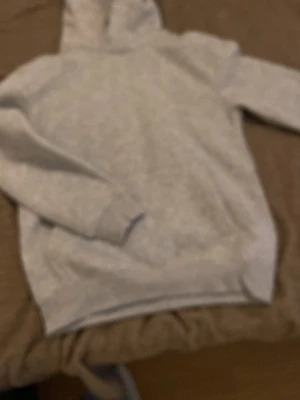 Grå hoodie från H&M - En basic grå hoodie från H&M i mjukt material. Klassisk modell med huva och långa ärmar, perfekt för en chill och avslappnad stil. Passar till det mesta och är superenkel att matcha med jeans eller joggers.